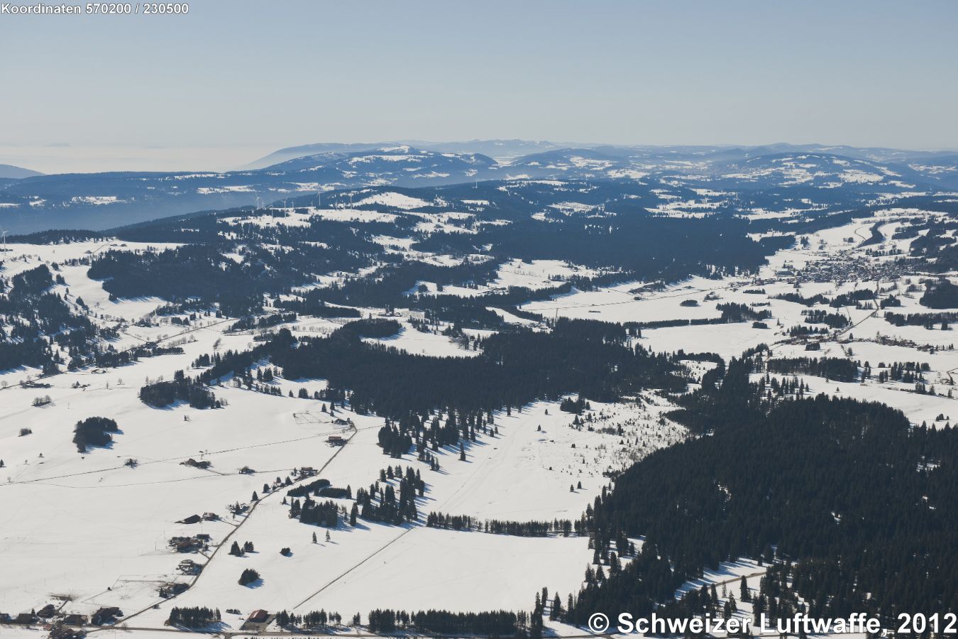 Franches Montagnes: grössere Siedlung Bildrand rechts Mitte: Les Breuleux, davor: La Chaux des Breuleux. Auf dem Hügelzug links obere Mitte: Windpark Mont Crosin.